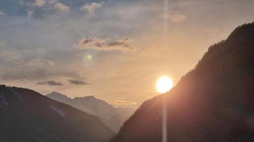 a sun setting on the side of a mountain at Laimbruchhof Apartments Urlaub auf dem Bauernhof in Val di Vizze