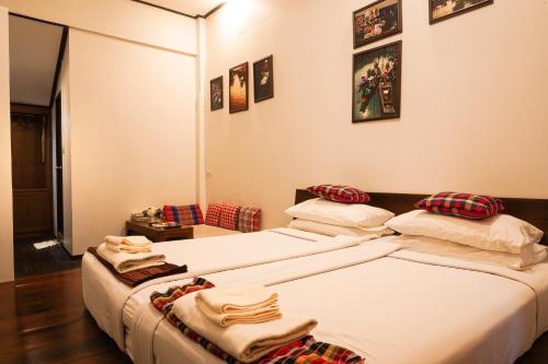 two beds in a hotel room with towels on them at Thanicha Resort Amphawa in Amphawa