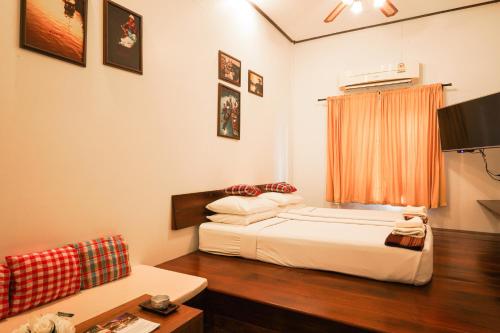 a bedroom with a bed and a television in it at Thanicha Resort Amphawa in Amphawa