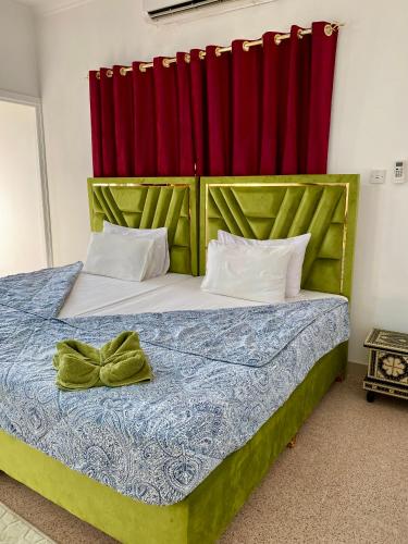 a bedroom with a bed with red curtains at Arabian Nights Nook in Muscat