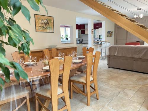 a dining room with a wooden table and chairs at Villa Isaac - Piscine naturelle - Proche Boulerie Jump - 8p in Le Mans