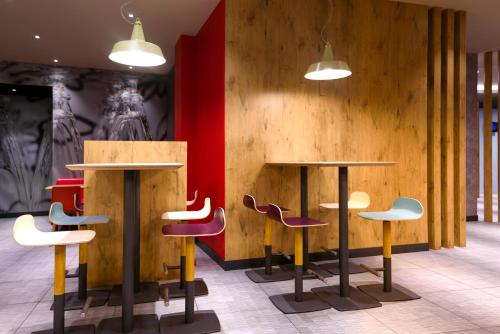 a lobby with two tables and chairs and a red wall at Ibis Bilbao Centro in Bilbao