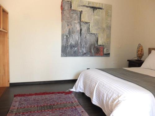 a bedroom with a bed and a painting on the wall at Peralta Villas Boutique Adults Only in Renau