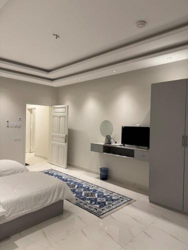 a bedroom with a bed and a flat screen tv at All the services are available at home in Ḑubā
