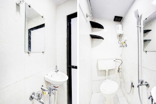 a white bathroom with a toilet and a sink at Super Hotel O BKC Santacruz East in Mumbai