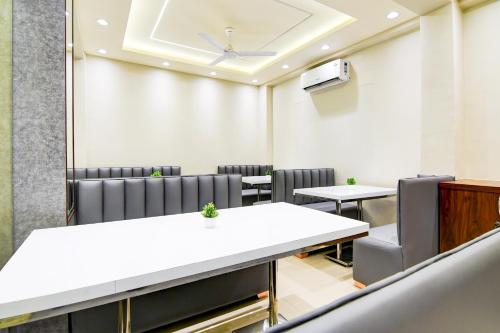 a conference room with tables and chairs and a ceiling at Super Townhouse Kaikhali Near Airport in Kolkata
