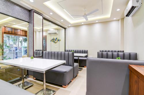 a waiting room with a table and chairs at Super Townhouse Kaikhali Near Airport in Kolkata