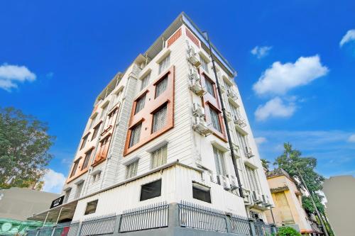 a tall white building with a blue sky in the background at Super Townhouse Kaikhali Near Airport in Kolkata