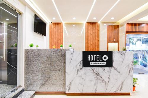 a lobby of a hotel with a marble counter at Super Townhouse Kaikhali Near Airport in Kolkata