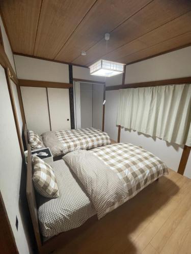 two twin beds in a room with a window at 福苑李 in Osaka
