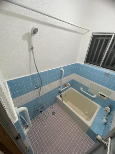 a bathroom with a bath tub with blue tiles at 福苑李 in Osaka