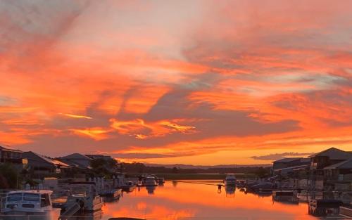 a sunset over a marina with boats in the water at Lakeview Yamba Waters in Yamba