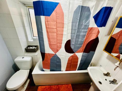 a bathroom with a toilet and a shower curtain at Chic 2BR escape near Luton Airport&Train Stn, Whipsnade zoo, Contractors in Luton
