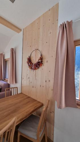 a dining room table with a wreath on the wall at Laimbruchhof Apartments Urlaub auf dem Bauernhof in Val di Vizze