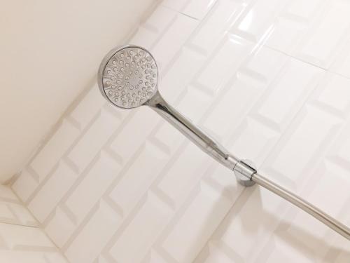 un cabezal de ducha en la pared del baño en Beriruang at Grand Asia Afrika Apartement, en Bandung