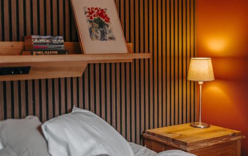 a bedroom with a bed and a table with a lamp at Hällesdalens Gård - semesterhus i Bohuslän in Svenshögen