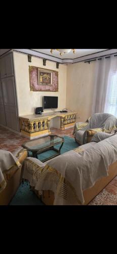 a living room with two beds and a table at Appartement avec jacuzzi in Mahires