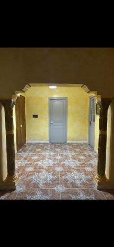 an empty room with a door and a tile floor at Appartement avec jacuzzi in Mahires