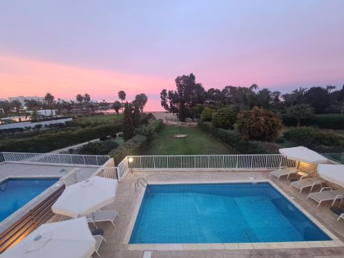 a swimming pool with two lounges and a swimming poolvisor at Horizon Villa Protaras in Protaras