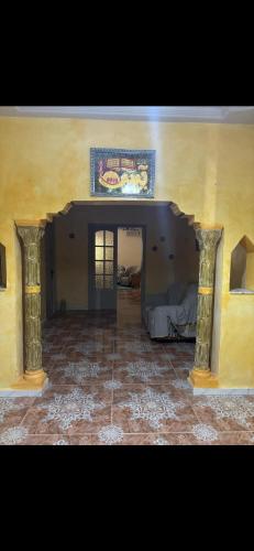 a room with a yellow wall and a room with a bed at Appartement avec jacuzzi in Mahires