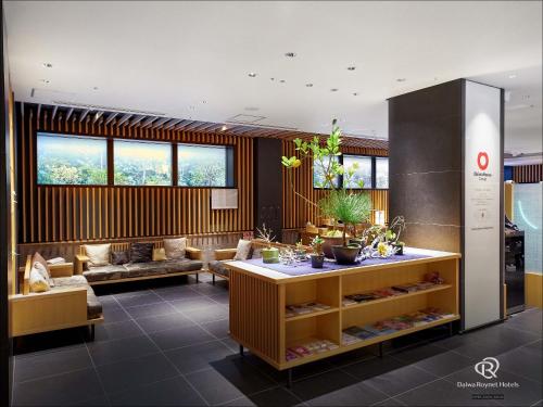 a living room with a couch and a table at Daiwa Roynet Hotel Kyoto Ekimae PREMIER in Kyoto