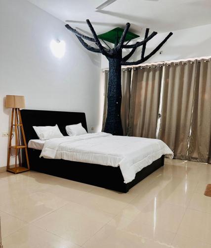 a bedroom with a bed with a tree on the ceiling at Elite stays viman nagar in Pune