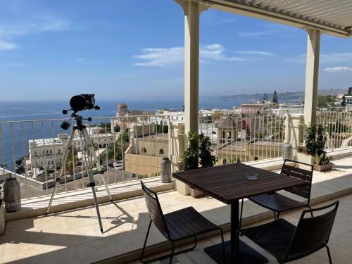 a camera on a tripod on a balcony with a table at Est hotel in Santa Cesarea Terme