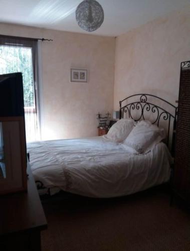 une chambre avec un lit avec des draps blancs et une fenêtre dans l'établissement Chez Nat, à Toulon