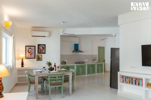 a kitchen and dining room with a table and chairs at StayVista at Suite De Regal in Mandrem