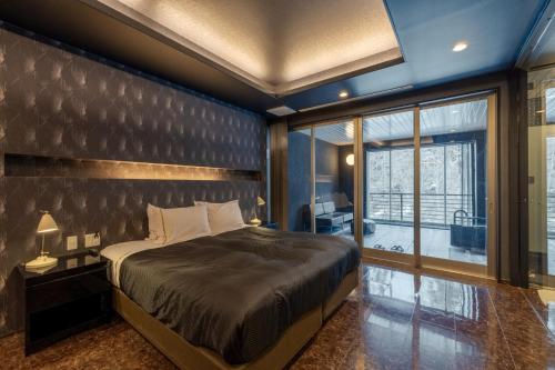 a bedroom with a large bed and a large window at Namari Onsen Kokoro No Toki Jusangatsu in Hanamaki