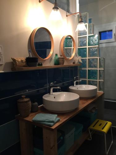 deux lavabos dans une salle de bain avec deux miroirs dans l'établissement Colorful 1930s house, à Portes-lès-Valence