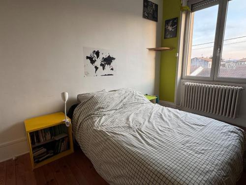 une chambre avec un lit et une fenêtre dans l'établissement Colorful 1930s house, à Portes-lès-Valence