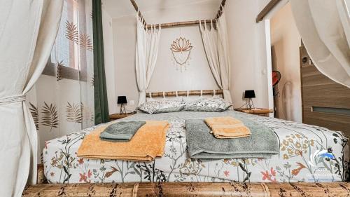 a bedroom with a bed with towels on it at Chalet Tikaz Sandjo in LʼEntre-Deux