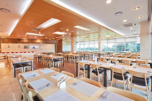 a dining room with wooden tables and chairs at Kumho Jeju Resort in Seogwipo