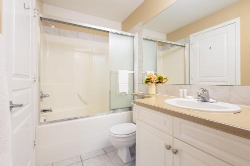 a bathroom with a sink and a toilet and a shower at Paradise Canyon Golf Resort - Luxury Villa 409 in Lethbridge