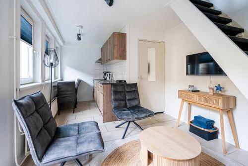 a living room with a desk and chairs and a table at Duinhotel Haga in Zoutelande