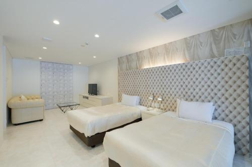 a hotel room with two beds and a television at Namari Onsen Kokoro No Toki Jusangatsu in Hanamaki
