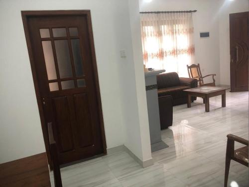 a living room with a wooden door and a couch at Crystal residence kandy in Gurudeniya
