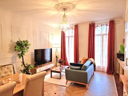 un salon avec un canapé et une télévision dans l'établissement Le Classique, à Montpon-Ménestérol