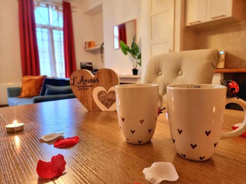 deux tasses à café posées sur une table en bois avec des cœurs dans l'établissement Le Classique, à Montpon-Ménestérol