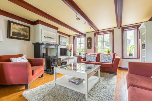 a living room with two couches and a fireplace at Winsum - Groningen - 6 pers. Cosy Cottage - Op en Bie t Woater in Winsum