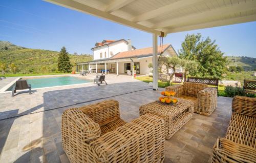 a patio with wicker furniture and a swimming pool at Dimora Di Famiglia in Belmonte Mezzagno