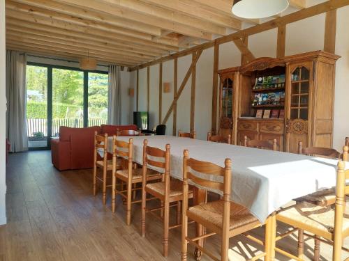 une salle à manger avec une grande table et des chaises dans l'établissement Gite du domaine, au coeur d'une ferme en activité, à Piney