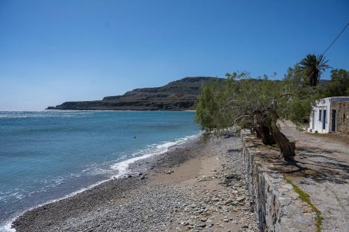 a beach with a retaining wall next to the water at Xrisanthy's House in Káto Zákros