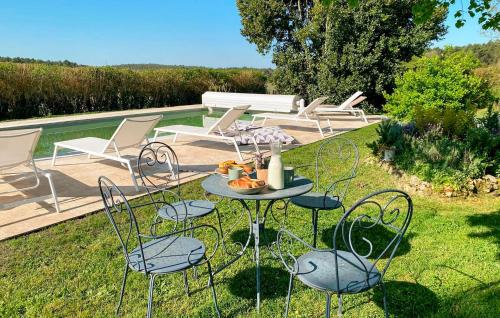 a patio with chairs and a table in the grass at Nice Home In Saint-Géraud-De-Corps in Saint-Géraud-de-Corps