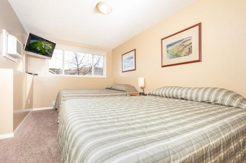une chambre avec un grand lit et une fenêtre dans l'établissement Paradise Canyon Golf Resort - Luxury Condo M409, à Lethbridge