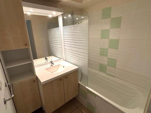 une salle de bain avec un lavabo et une douche dans l'établissement Appartement plage, piscine, tennis, nature, à Ondres