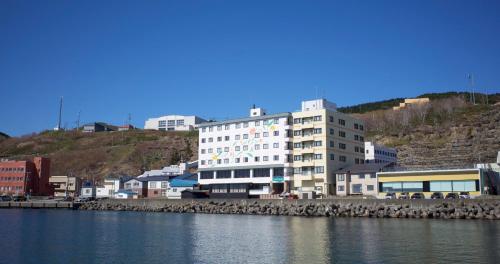 a large white building next to a body of water at REBUN Hotel SARYO in Kafuka