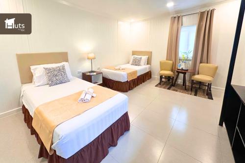 a hotel room with two beds and a table and chairs at Huts by Little Green Kitchen in Utap