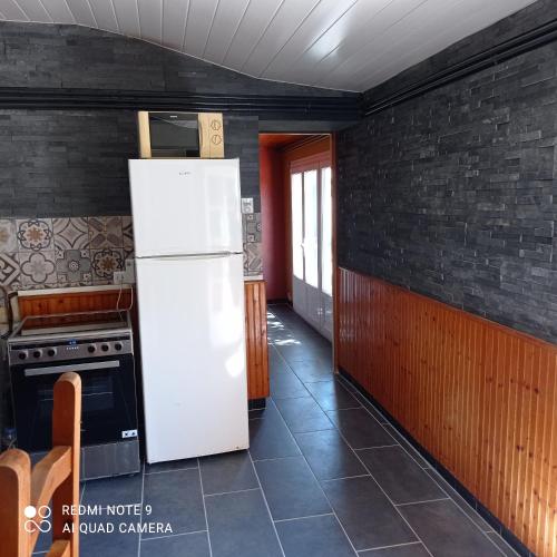 a kitchen with a refrigerator and a stove at Maison de vacances près de la Tranche sur mer in Angles